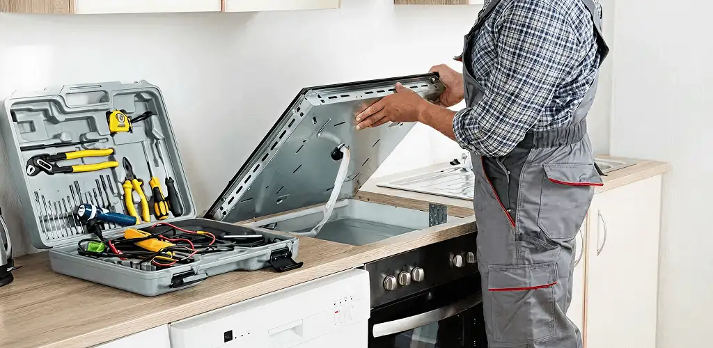 Handyman repairing a cooktop and checking wiring connections in Akron, OH