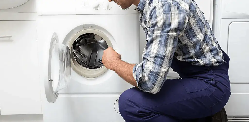 Handyman inspecting a dryer drum and internal parts for repair in Akron, OH