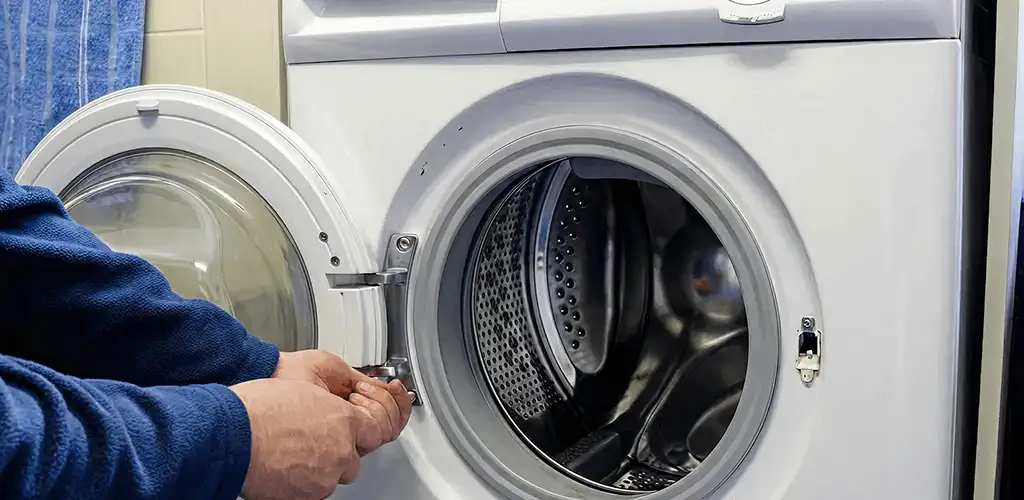 Washing machine repair handyman checking a front-load washer door and latch in Akron, OH