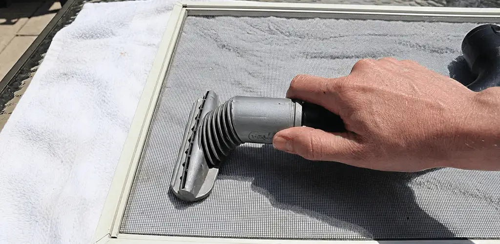 Window screen repair cleaning and fixing a damaged screen mesh in Akron, OH